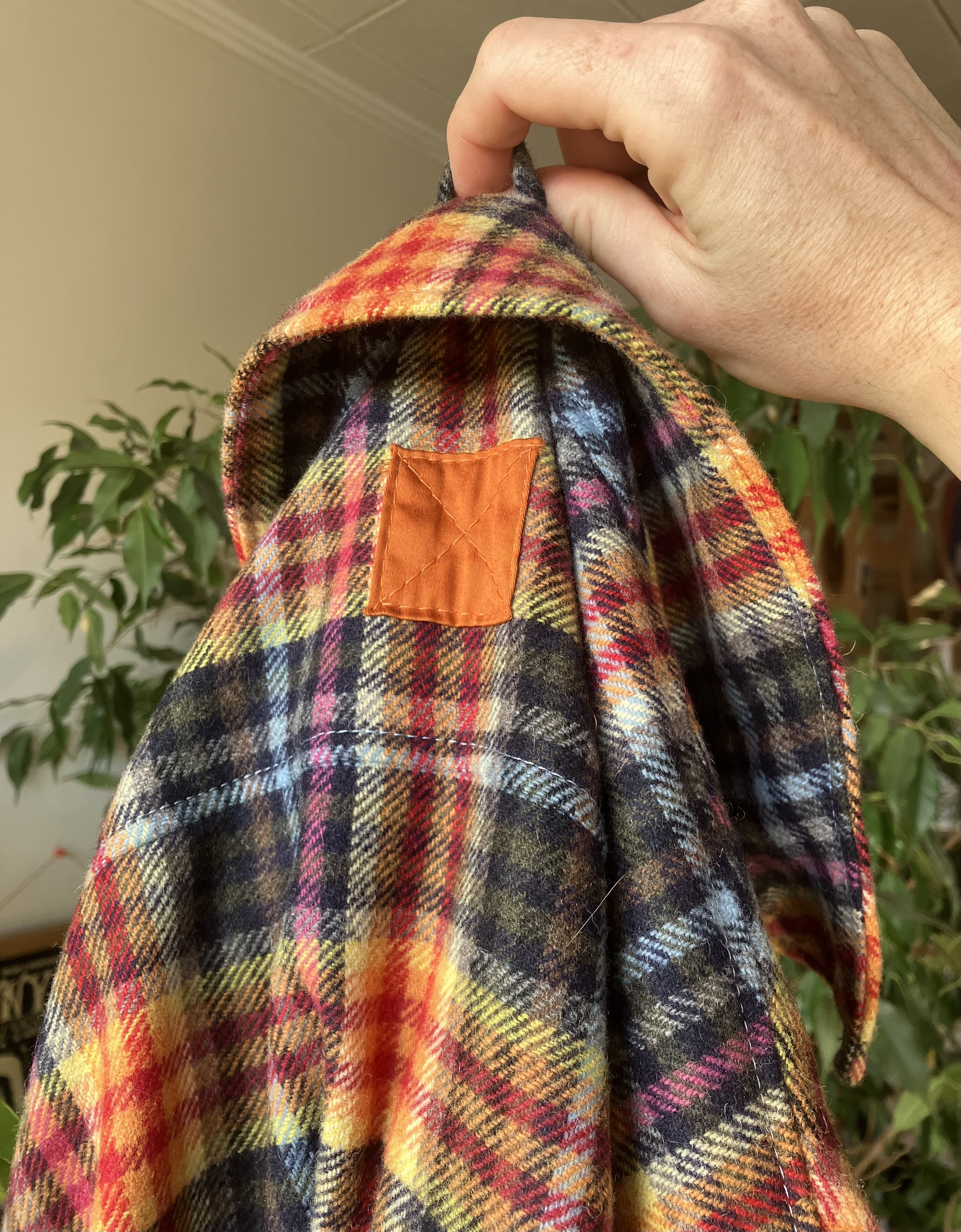 photo du dos de la surchemise en tartan, une pièce de tissu en satin orange a été cousue pour orner le haut du dos